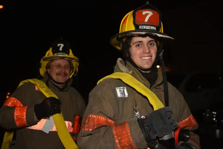 Two volunteer firefighters smiling
